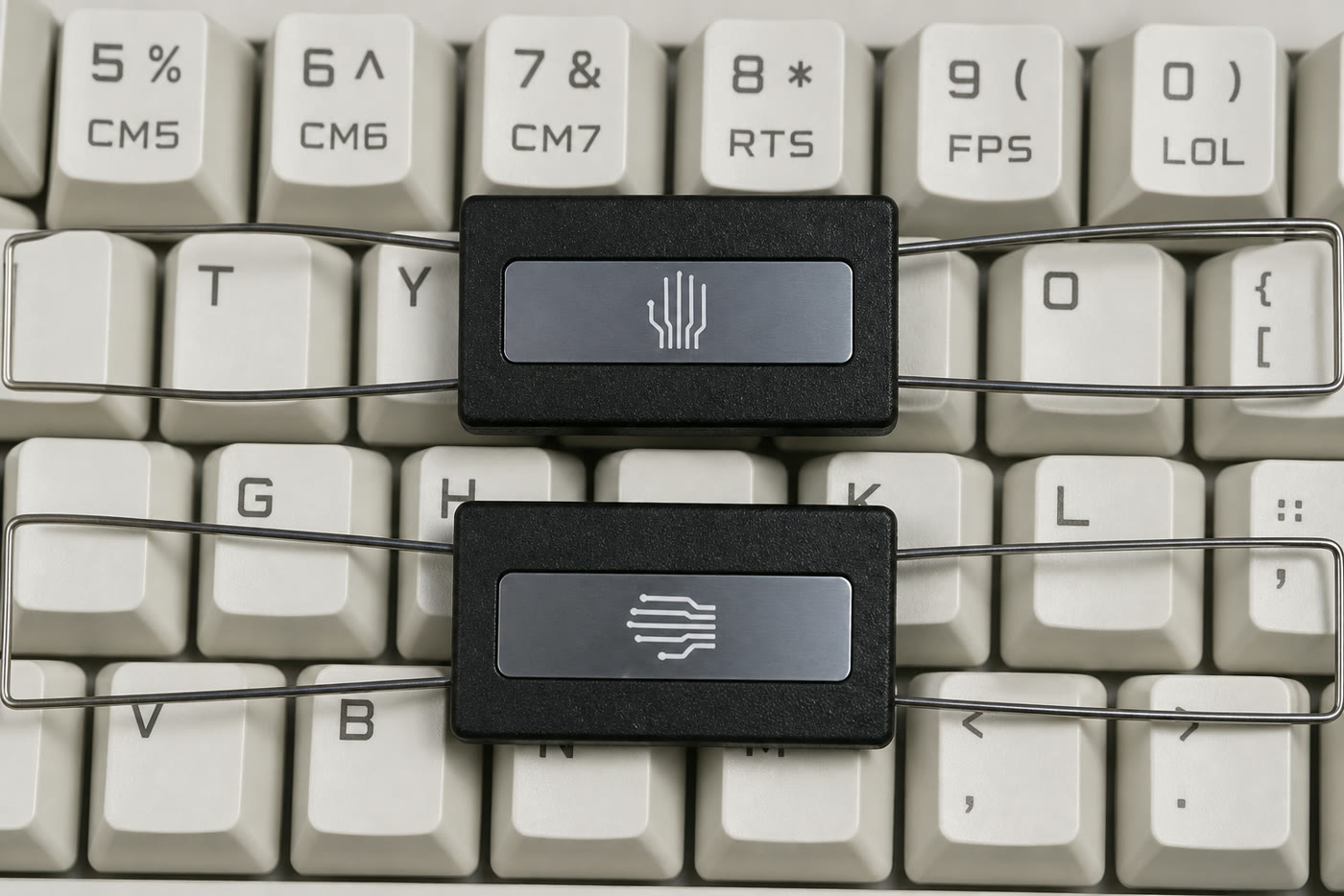 Two keyboard wire keycap pullers customized with client symbols